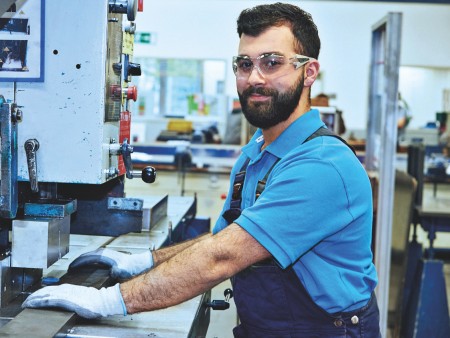 Young man with beard and black hair, in blue polo shirt and work clothes