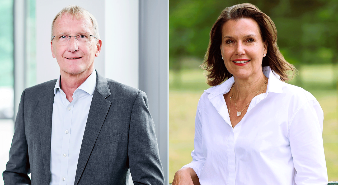 Mann (Winfried Schulte) im Anzug, schaut lächelnd in die Kamera , Frau (Dr. Lisbeth Jacobs) im weißen Hemd schaut lächelnd in die Kamera.