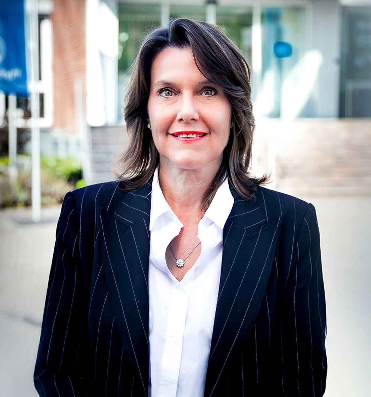 Frau, lächelnd, weißes Hemd, schwarzer Blazer